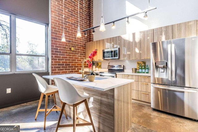 kitchen with finished concrete flooring, modern cabinets, a breakfast bar area, a center island, and stainless steel appliances