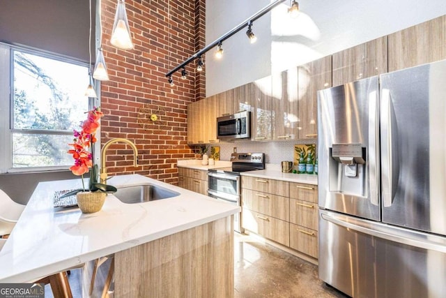 kitchen with light brown cabinets, a sink, appliances with stainless steel finishes, modern cabinets, and finished concrete floors