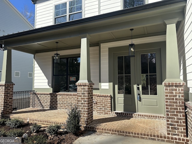 entrance to property with covered porch and brick siding