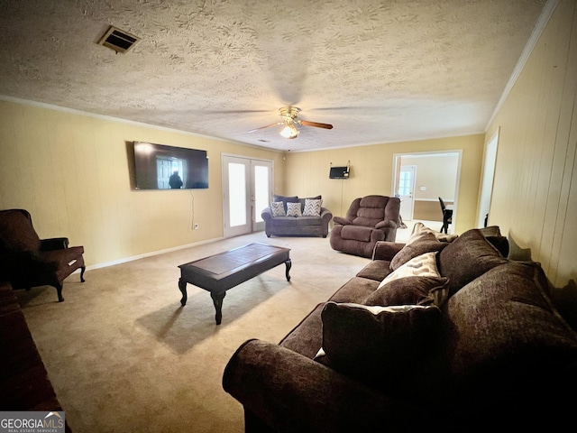 living room featuring visible vents, french doors, carpet flooring, and ornamental molding