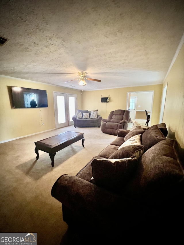 living area featuring carpet, french doors, a textured ceiling, and baseboards