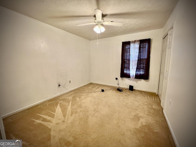 interior space featuring a ceiling fan, a textured ceiling, and baseboards