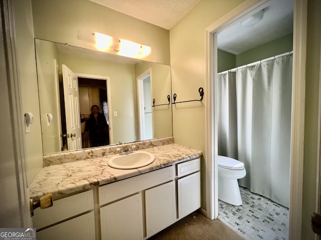 bathroom featuring toilet, a textured ceiling, and vanity