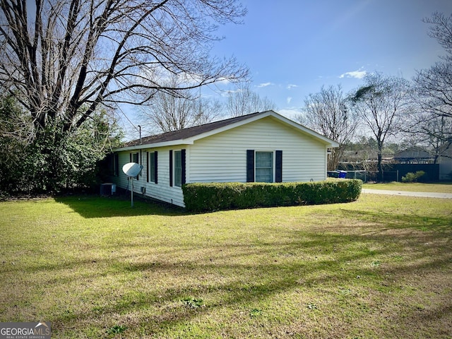 view of side of property featuring a lawn and central air condition unit