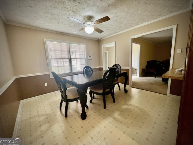 dining area featuring ornamental molding, a ceiling fan, a textured ceiling, baseboards, and tile patterned floors