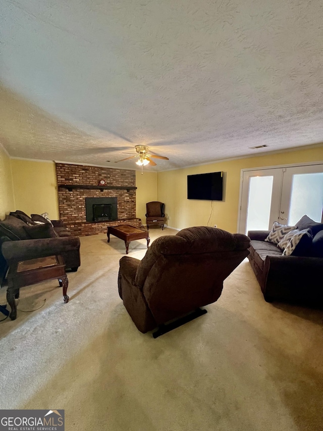 living area featuring french doors, visible vents, a brick fireplace, carpet flooring, and a textured ceiling