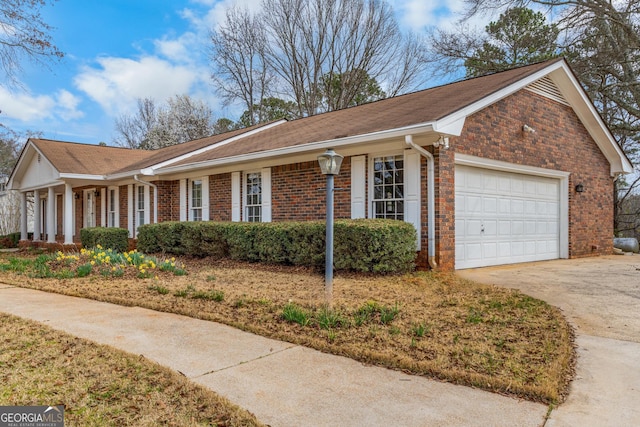 exterior space with a garage, concrete driveway, and brick siding