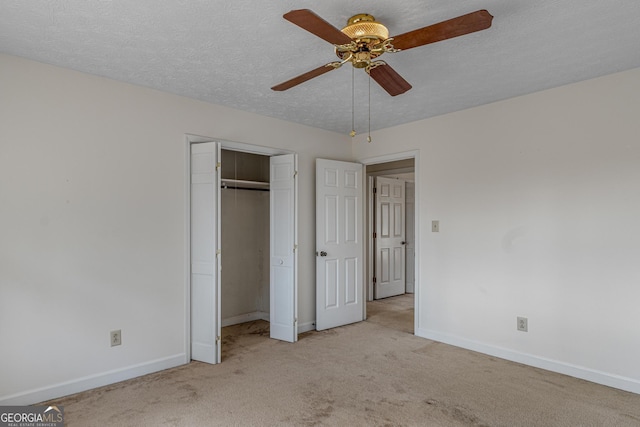 unfurnished bedroom featuring carpet floors, a closet, ceiling fan, a textured ceiling, and baseboards