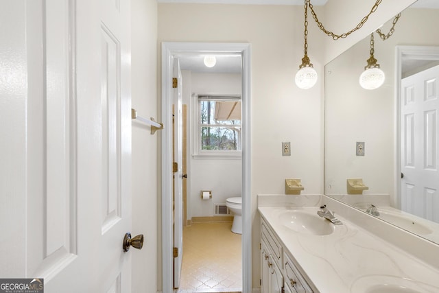 full bath with toilet, double vanity, visible vents, and a sink