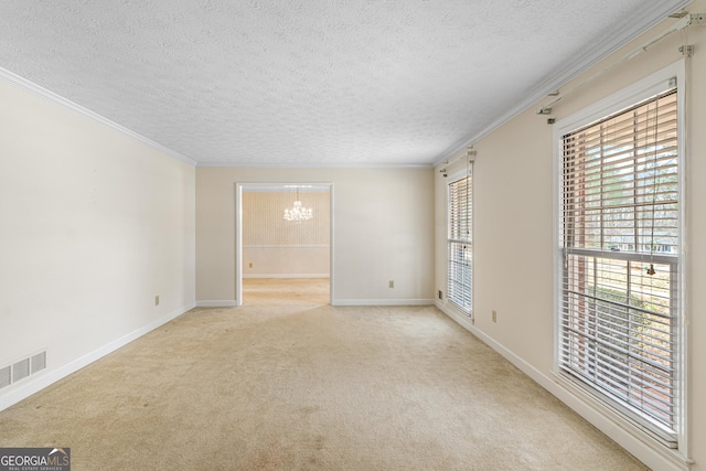 unfurnished room featuring a wealth of natural light, ornamental molding, visible vents, and a notable chandelier