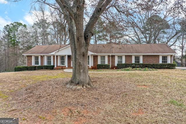 ranch-style house featuring brick siding and a front lawn