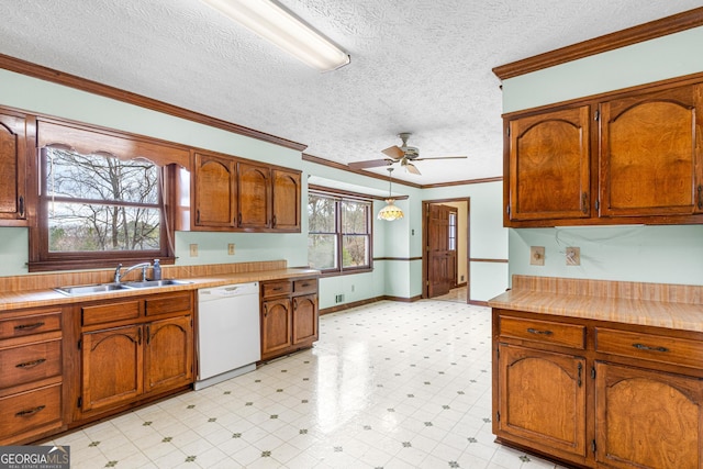 kitchen featuring light floors, light countertops, ornamental molding, white dishwasher, and a sink