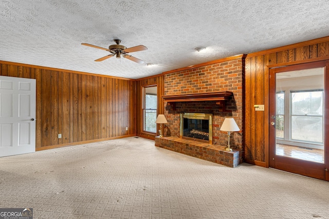 unfurnished living room featuring crown molding, a brick fireplace, and wooden walls