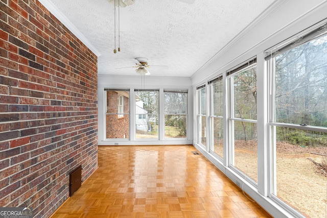 unfurnished sunroom featuring a ceiling fan and visible vents