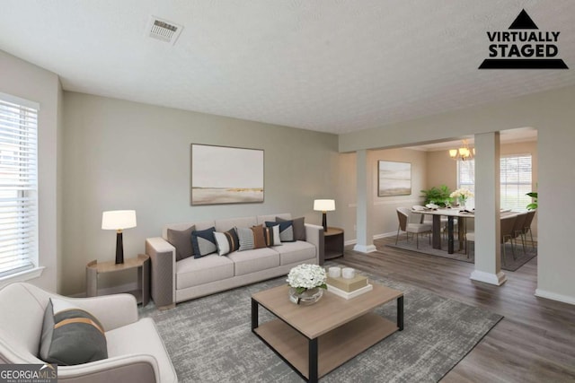 living room featuring plenty of natural light, wood finished floors, and visible vents