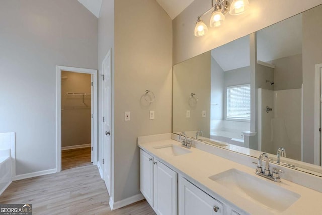 bathroom featuring lofted ceiling, a sink, and a bath