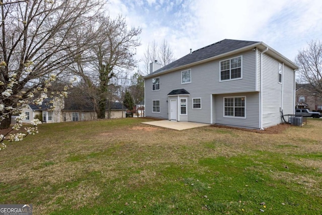 rear view of house featuring a patio, a chimney, and a lawn