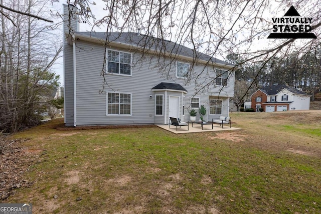 back of property with a patio area, a yard, and a chimney