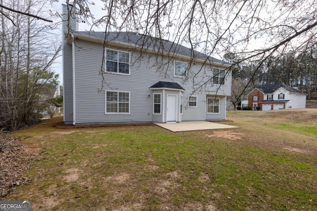 rear view of house with a patio, a chimney, and a lawn