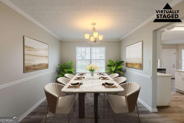 dining area featuring light wood-style floors, ornamental molding, a textured ceiling, and an inviting chandelier