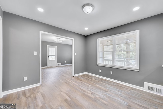 spare room with recessed lighting, wood finished floors, visible vents, and baseboards