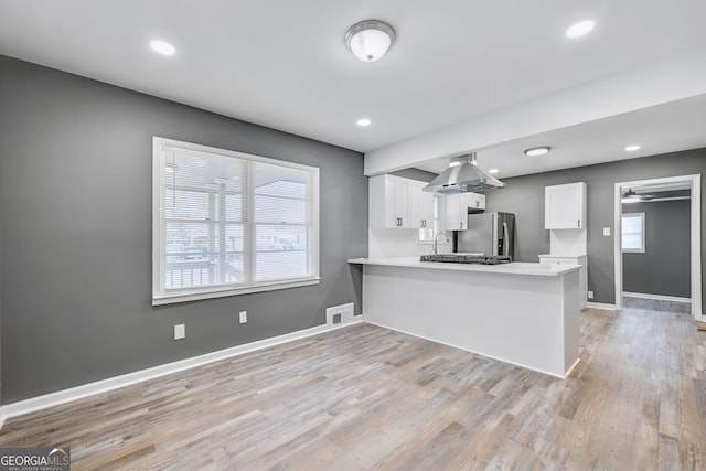 kitchen with light countertops, visible vents, light wood-style flooring, and white cabinetry