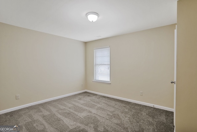 empty room featuring carpet floors and baseboards