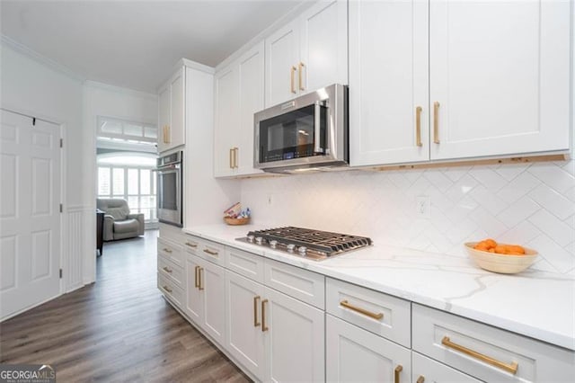 kitchen with light stone counters, crown molding, stainless steel appliances, white cabinetry, and wood finished floors