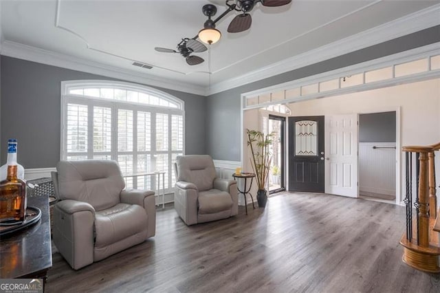sitting room with visible vents, wood finished floors, a ceiling fan, and wainscoting