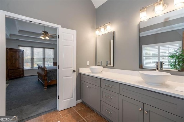 ensuite bathroom with ceiling fan, connected bathroom, double vanity, and a sink