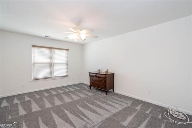 carpeted empty room with visible vents, ceiling fan, and baseboards