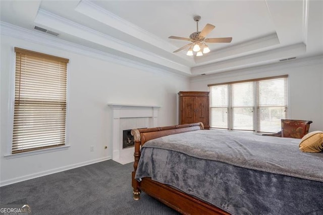 bedroom with crown molding, visible vents, and a tray ceiling