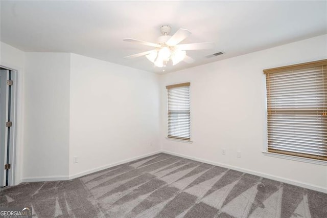 unfurnished room featuring carpet, visible vents, and baseboards