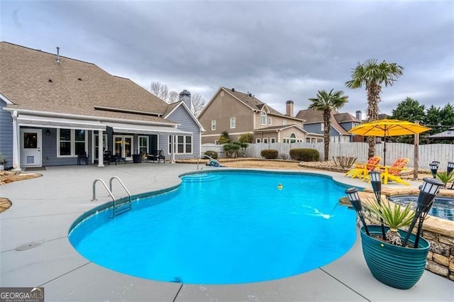 view of pool featuring a patio area, a fenced backyard, a fenced in pool, and french doors