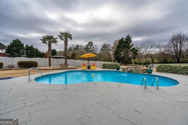 view of pool featuring a patio area, a fenced backyard, and a pool with connected hot tub