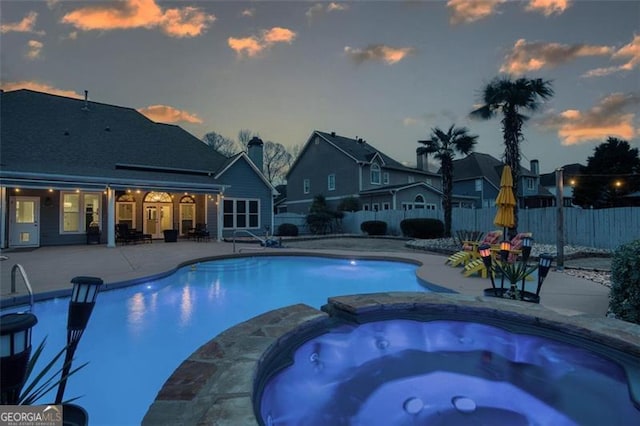 view of pool featuring a pool with connected hot tub, a patio, and a fenced backyard