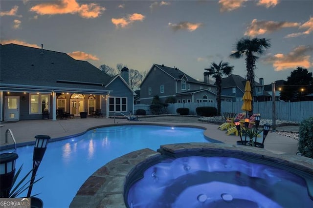 view of pool featuring a patio, a fenced backyard, and a pool with connected hot tub