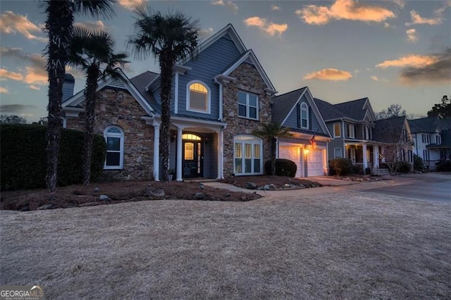 view of front of house with stone siding and driveway