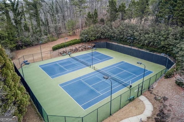 view of tennis court featuring fence