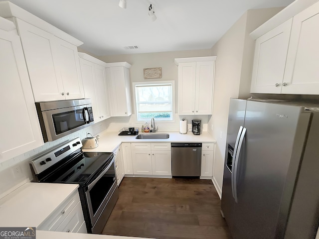 kitchen with light countertops, visible vents, appliances with stainless steel finishes, white cabinetry, and a sink