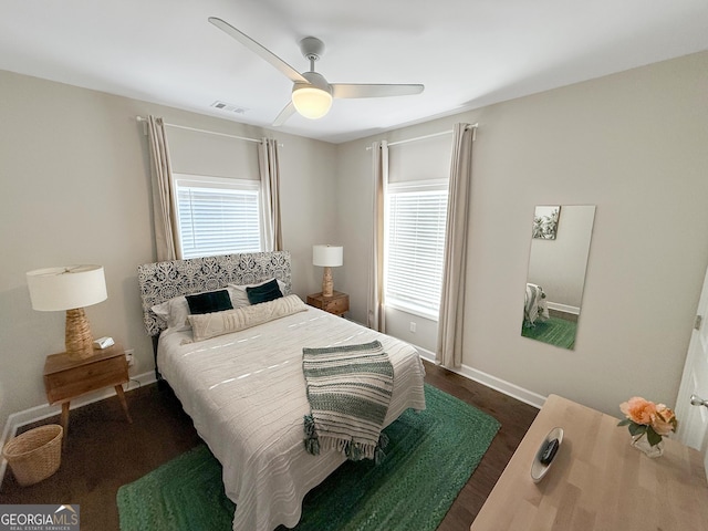 bedroom featuring baseboards, visible vents, ceiling fan, and wood finished floors