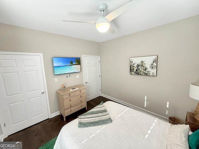 bedroom with dark wood-style flooring, a ceiling fan, and baseboards