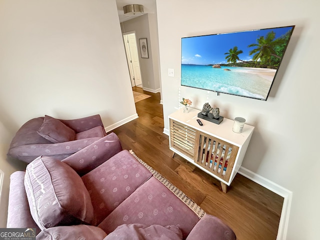 living area with baseboards and wood finished floors