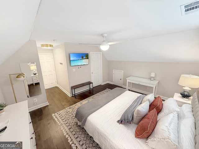 bedroom with baseboards, visible vents, a ceiling fan, dark wood-style floors, and vaulted ceiling