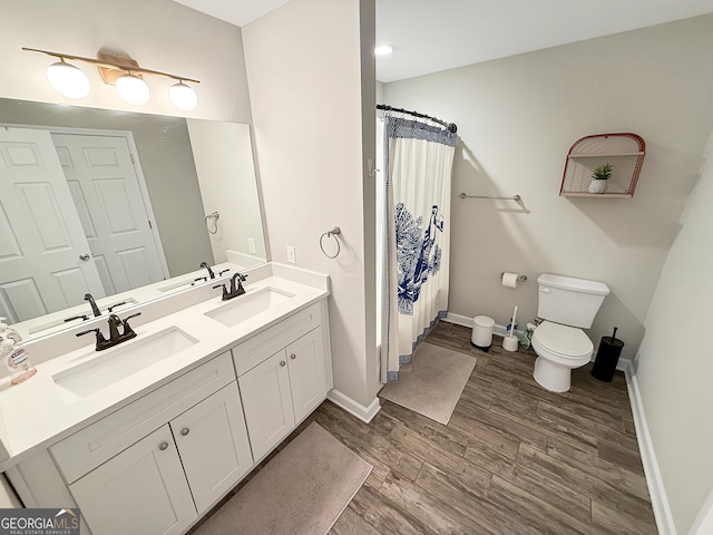 bathroom featuring a sink, toilet, and wood finished floors