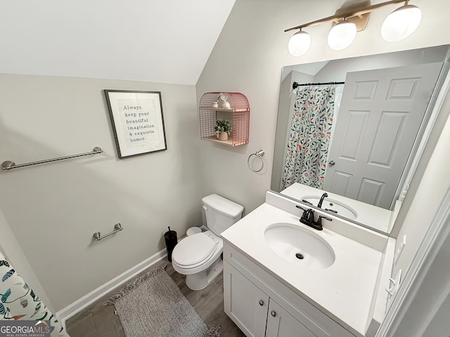 bathroom with lofted ceiling, a shower with shower curtain, toilet, vanity, and baseboards