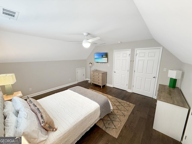 bedroom featuring lofted ceiling, baseboards, visible vents, and dark wood finished floors