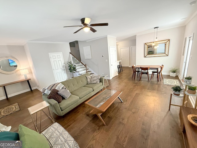 living room featuring baseboards, wood-type flooring, stairway, and crown molding