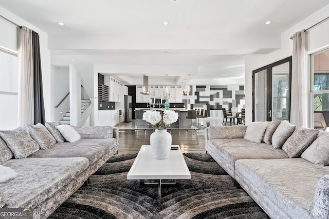 living room featuring recessed lighting, dark wood-style flooring, and stairs