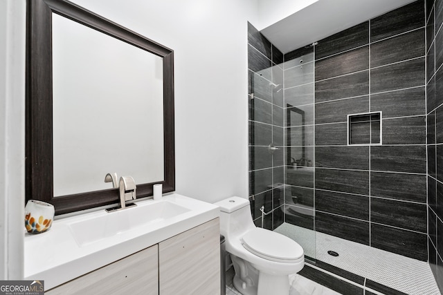 bathroom featuring vanity, toilet, and a tile shower